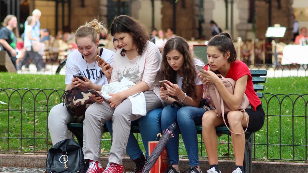 un grupo de adolescentes utilizando sus moviles