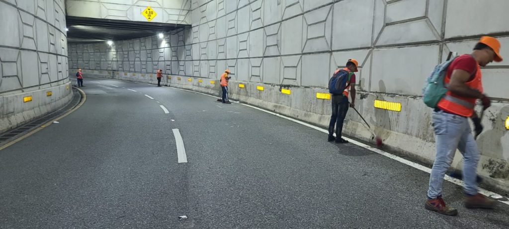 Empleados le dan mantenimiento a una vía de RD